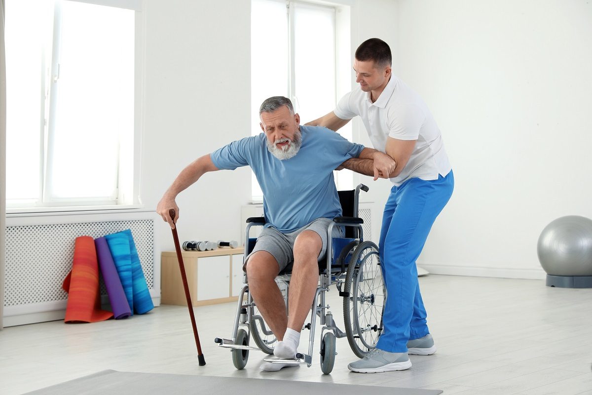 Fisioterapeuta ayudando a una persona mayor con sus ejercicios de neurorehabilitación